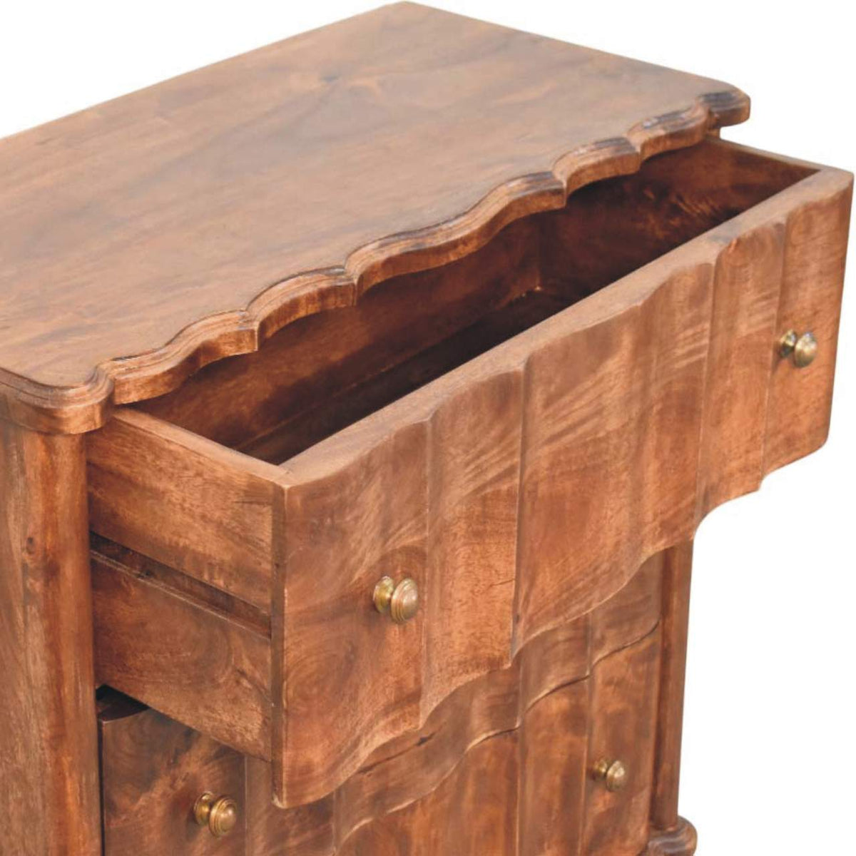 High-angle view showing the top drawer pulled open on a panelled solid mango wood chest in roasted almond, revealing the interior wooden drawer box.