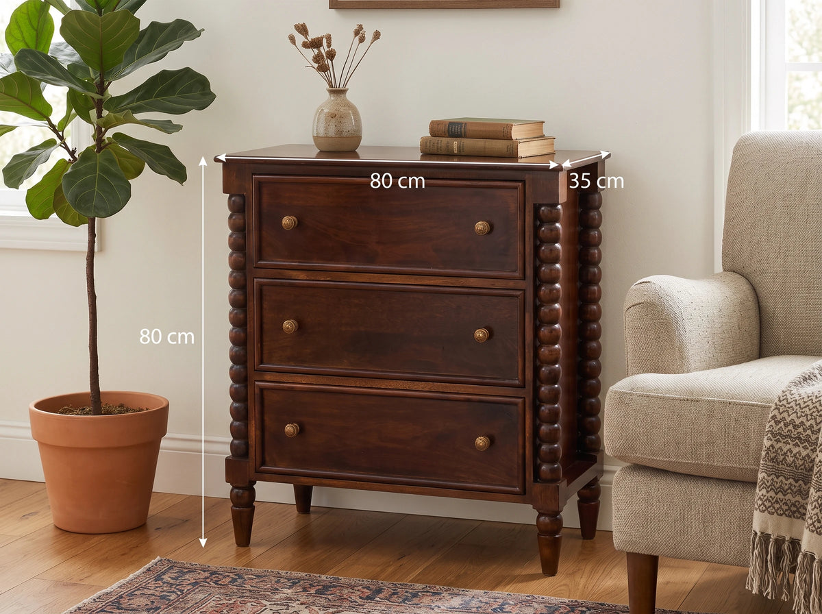 Lifestyle image of a Winewood Oak solid mango wood 3-drawer spindle chest next to an armchair, with dimension overlays indicating 80 cm width, 35 cm depth, and 80 cm height.