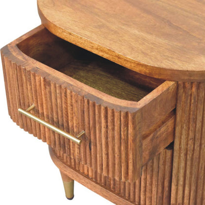 High-angle view showing the top drawer pulled open on an amber oak ribbed bedside table, revealing the wooden interior storage compartment.