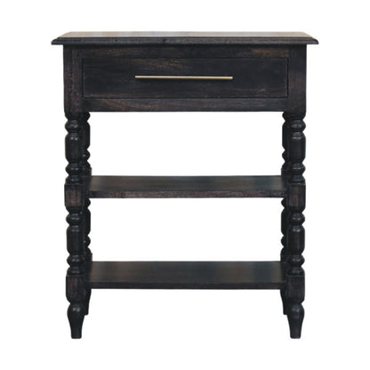 Front view of a solid mango wood turned-leg side table in a carbon ash finish, featuring a single drawer with a brass handle and two open lower shelves.