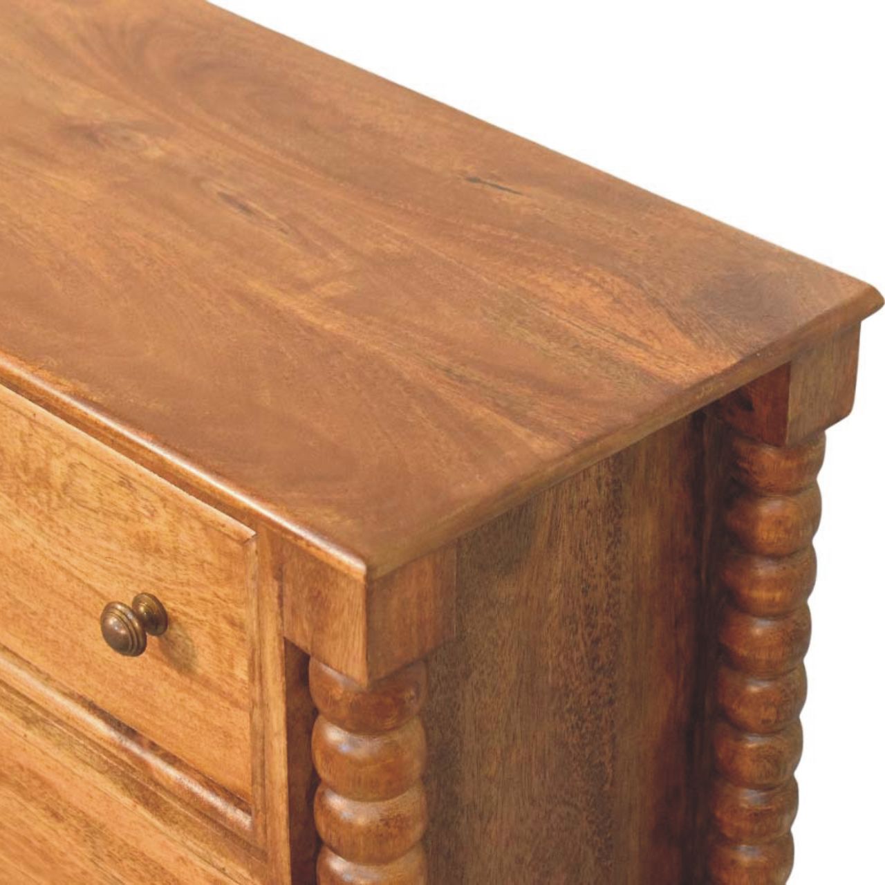 Close top right angle of the Chest of Drawers showing natural mango wood grain and honeyed tones