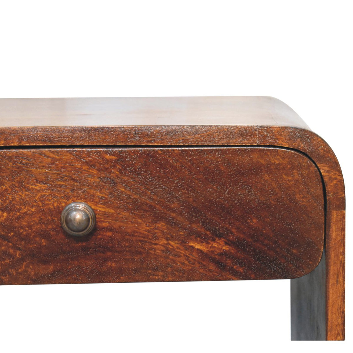 Close-up detail of the smooth curved top right corner and the single drawer with a dark metal knob on a chestnut bedside table.