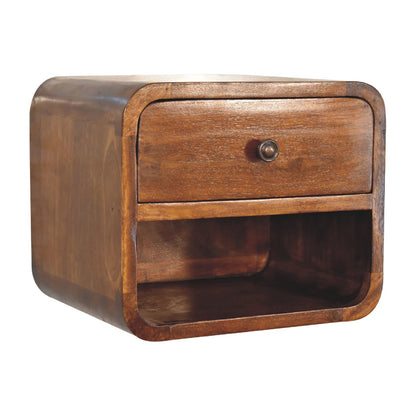 Angled left perspective of a chestnut floating bedside table, highlighting its seamless curved silhouette and solid wood construction.