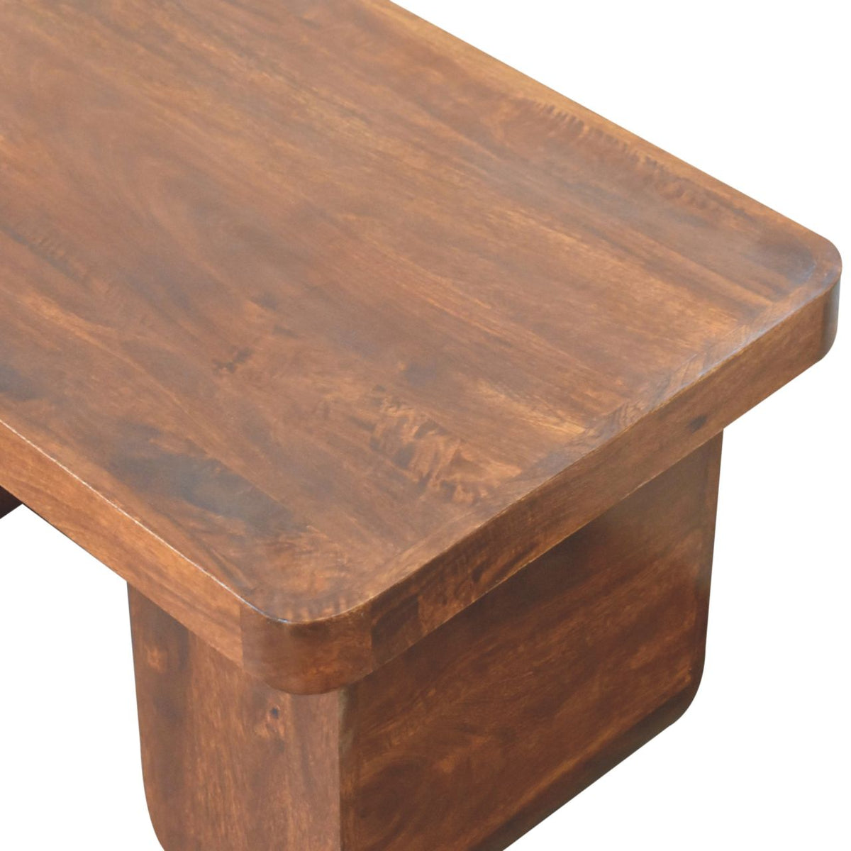 Elevated close-up angled view showing the smooth, thick solid mango wood top surface of a chestnut coffee table.