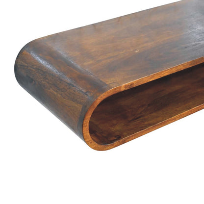 Floating arc media console in solid mango wood, Chestnut finish – wood grain detail, front left elevated close-up