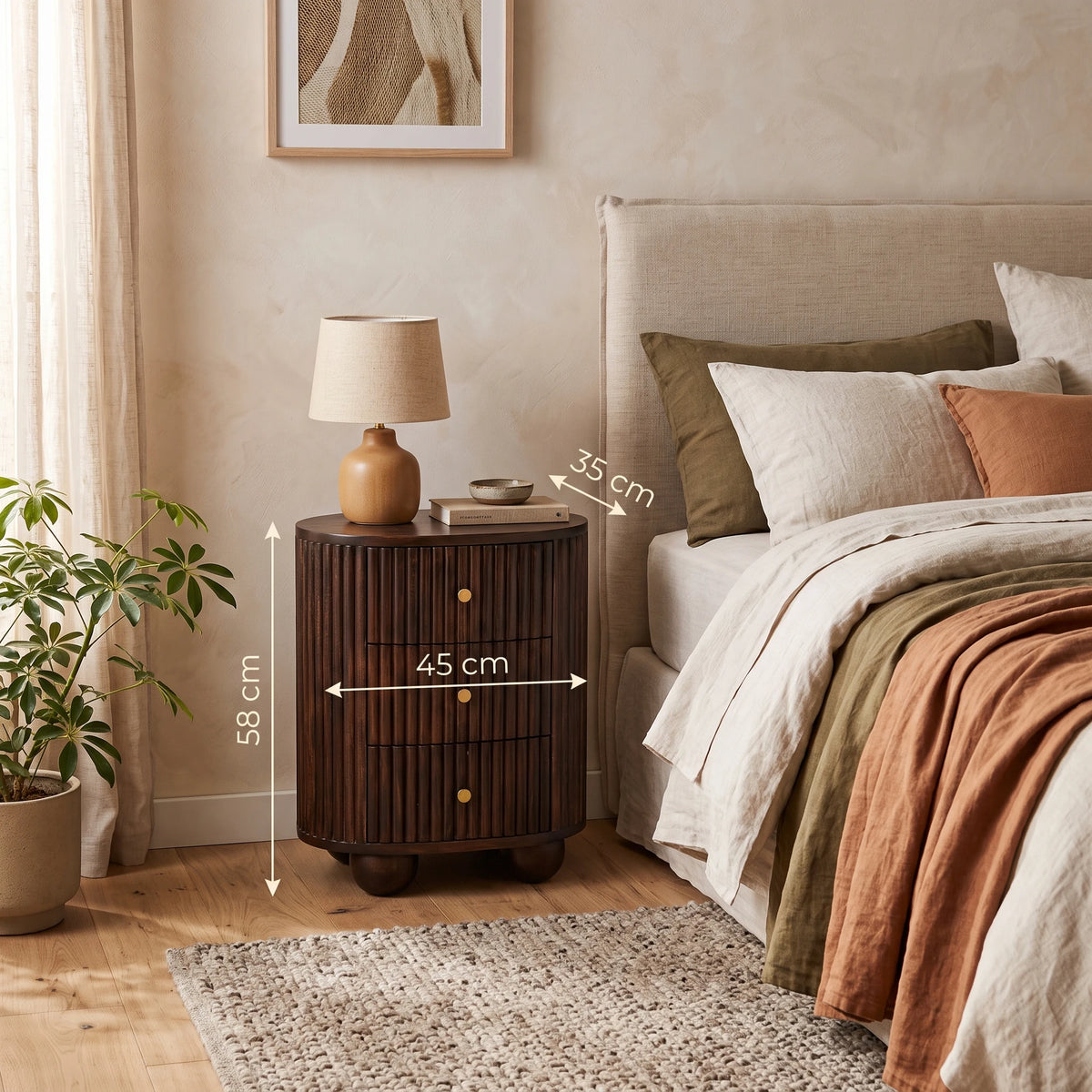 A fluted 3-drawer curved bedside table in solid mango wood with a velvet mocha finish, styled in a warm bedroom setting next to a bed with a small lamp on top. White dimension lines overlay the nightstand showing its height as 55 cm, width as 45 cm, and depth as 35 cm.