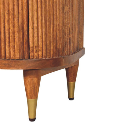 Detail shot of the tapered wooden legs with brass caps supporting a solid mango wood ribbed bedside table.