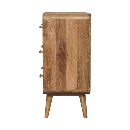 Straight-on side profile view of a solid mango wood chest of drawers in natural oak, showing the smooth, flat side panel and tapered legs.