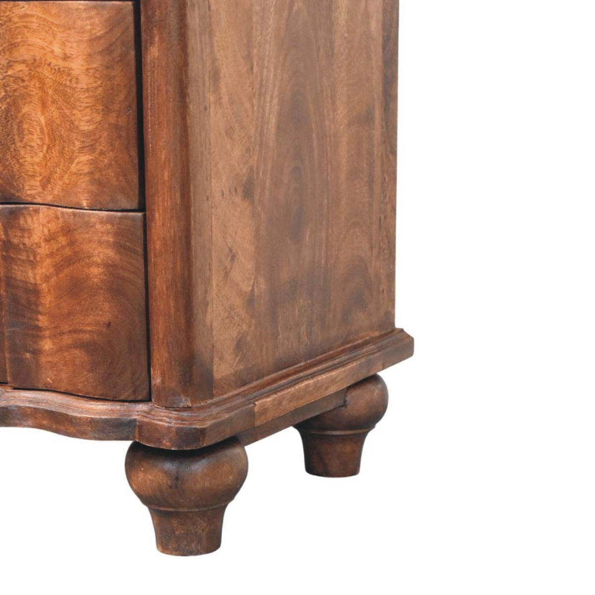 Detail shot of the scalloped base apron and the turned wooden bun feet supporting a roasted almond mango wood bedside table.
