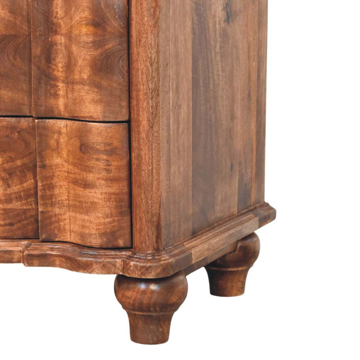 Detail shot of the scalloped base apron and the turned wooden bun feet supporting a roasted almond mango wood bedside table.