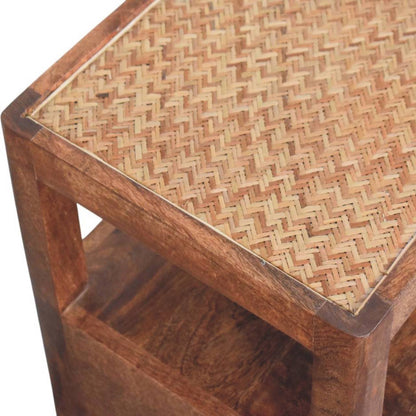 Detail shot of the woven rattan pattern and the solid wood corner joinery on the top of a honey caramel bedside table.