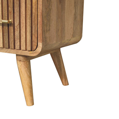 Detail view of the tapered, angled wooden legs and the bottom rounded corner of a natural oak ridged mango wood chest.