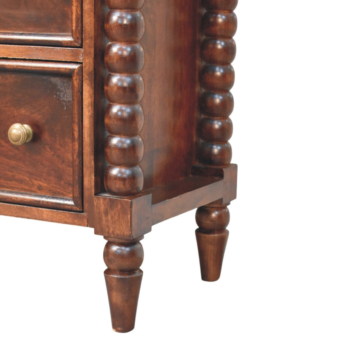 Close-up detail of the bottom right corner of the chest, showcasing the base of the spindle column and the tapered turned wooden foot.