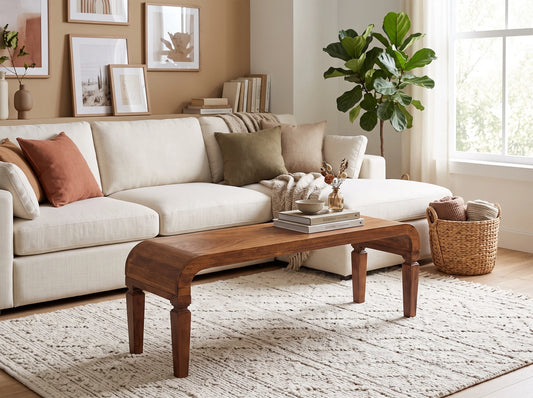 Solid mango wood coffee table in a warm amber oak finish, styled in a bright living room in front of a modern white sofa.