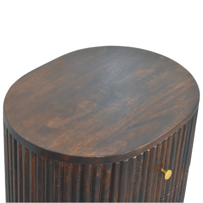 Elevated angled view showing the smooth, dark solid mango wood top surface of an oval-shaped velvet mocha bedside table.