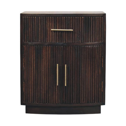 Front view of a solid mango wood bedside table in a velvet mocha finish, featuring a vertical fluted texture, one top drawer, two lower cabinet doors, and brass handles.