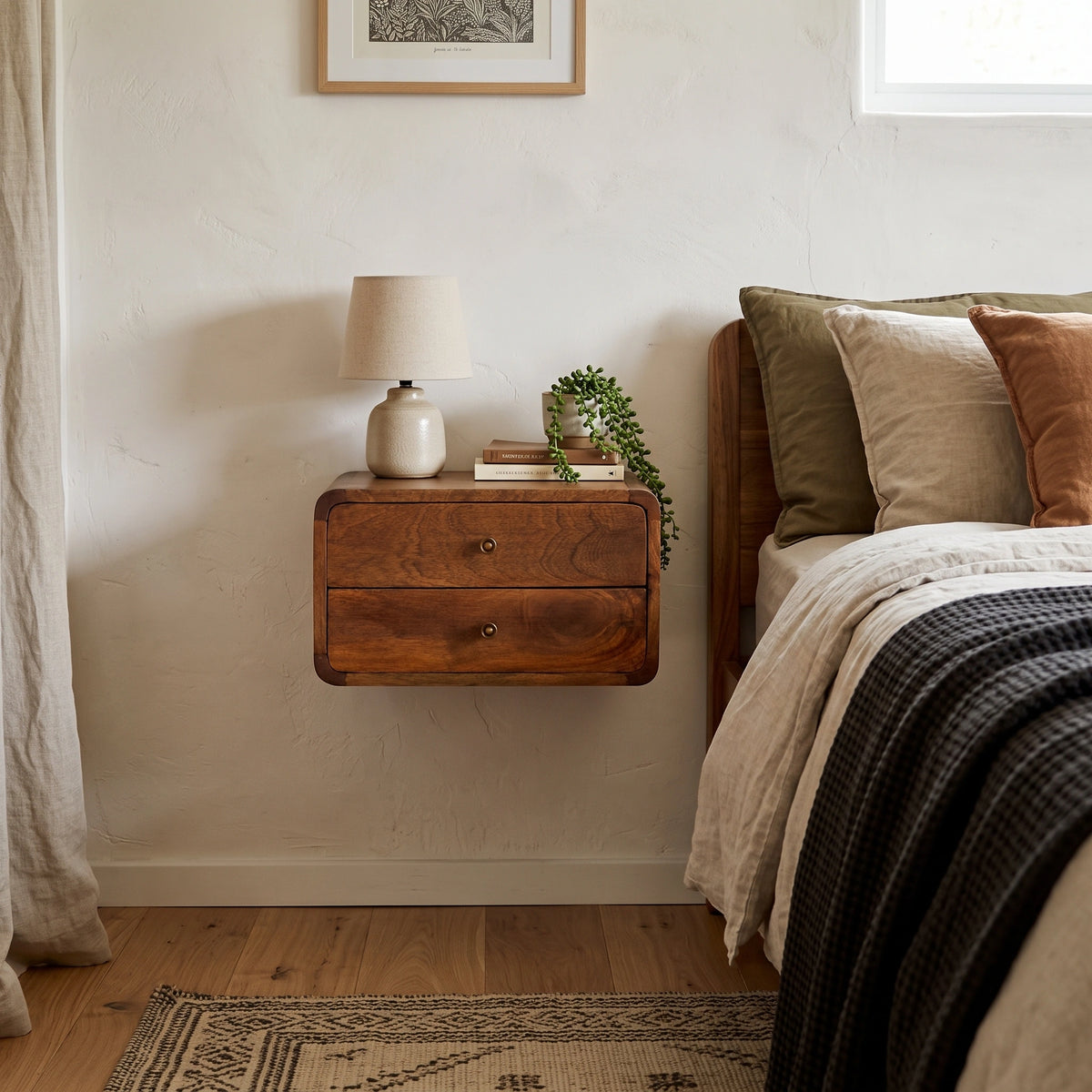 Floating Curved Mango Wood Bedside Table in chestnut finish in lifestyle