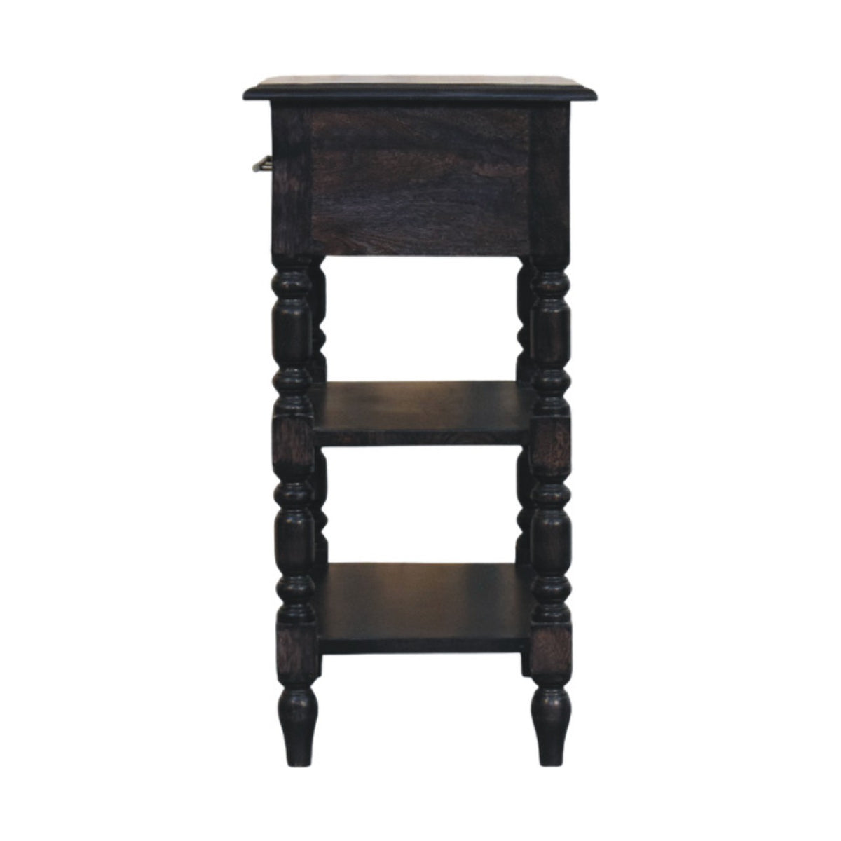 Straight-on side profile view of a solid mango wood 1-drawer side table in carbon ash, displaying its open shelves and turned leg silhouette.
