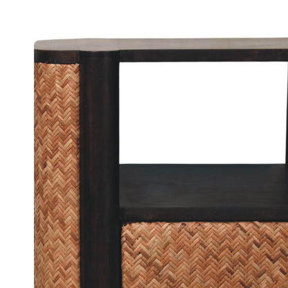 Close-up of the open shelf and rounded corner on a velvet mocha bedside table, highlighting the contrast between the dark wood and woven edge texture.
