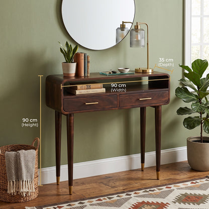 A dark wood console table with two drawers and open shelf, shown in a styled room with wall, mirror, lamp, plants, basket, and rug. White measurement callouts indicate 90 cm width, 90 cm height, and 35 cm depth.