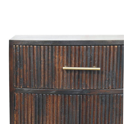 Close-up detail of the vertical fluted wood texture and a sleek brass bar handle on the top drawer of a velvet mocha bedside table.