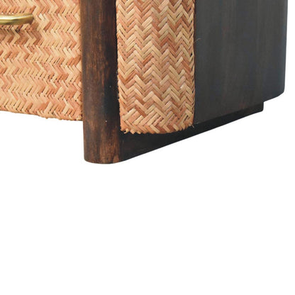 Close-up detail of the bottom corner of a velvet mocha bedside table, showing the rounded solid wood vertical post and the woven rattan side panel.
