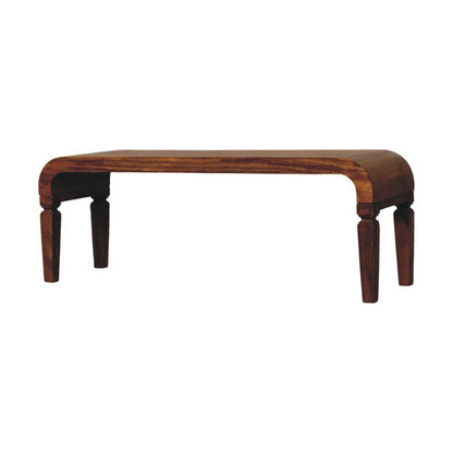 Angled front perspective of a solid mango wood coffee table in a warm amber oak finish.