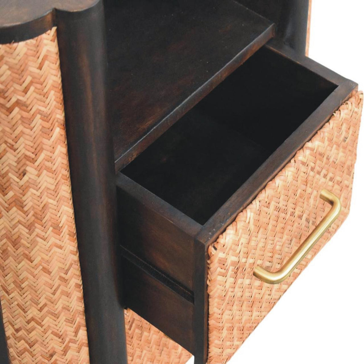 High-angle view showing the top drawer pulled open on a woven bedside table, revealing the dark wooden interior compartment.